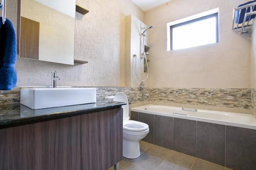 Modern bathroom with bathtub, sink vanity, and toilet