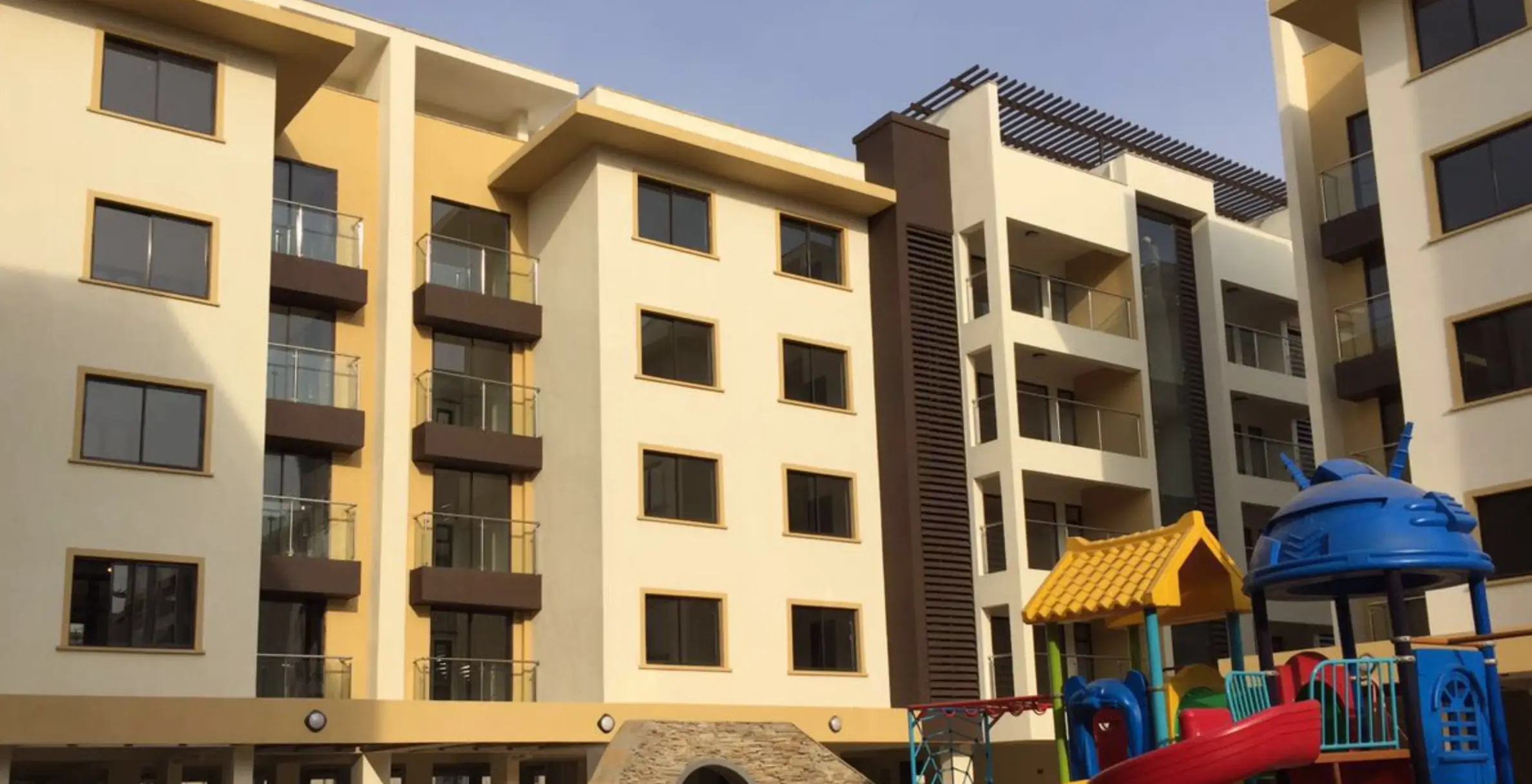 Multi-story residential building with yellow facade and balconies