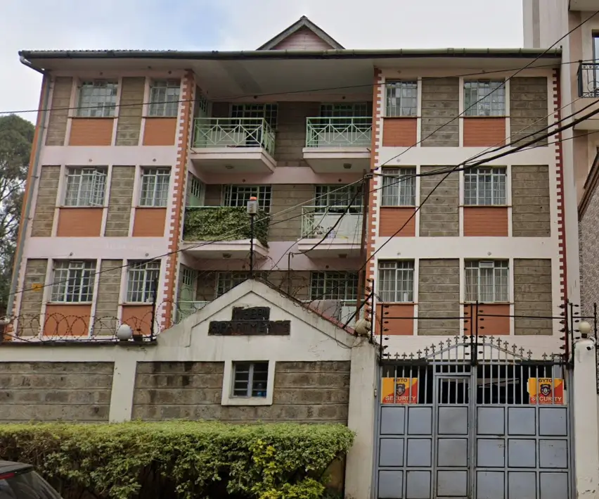 Multi-story residential building facade with orange and stone finish