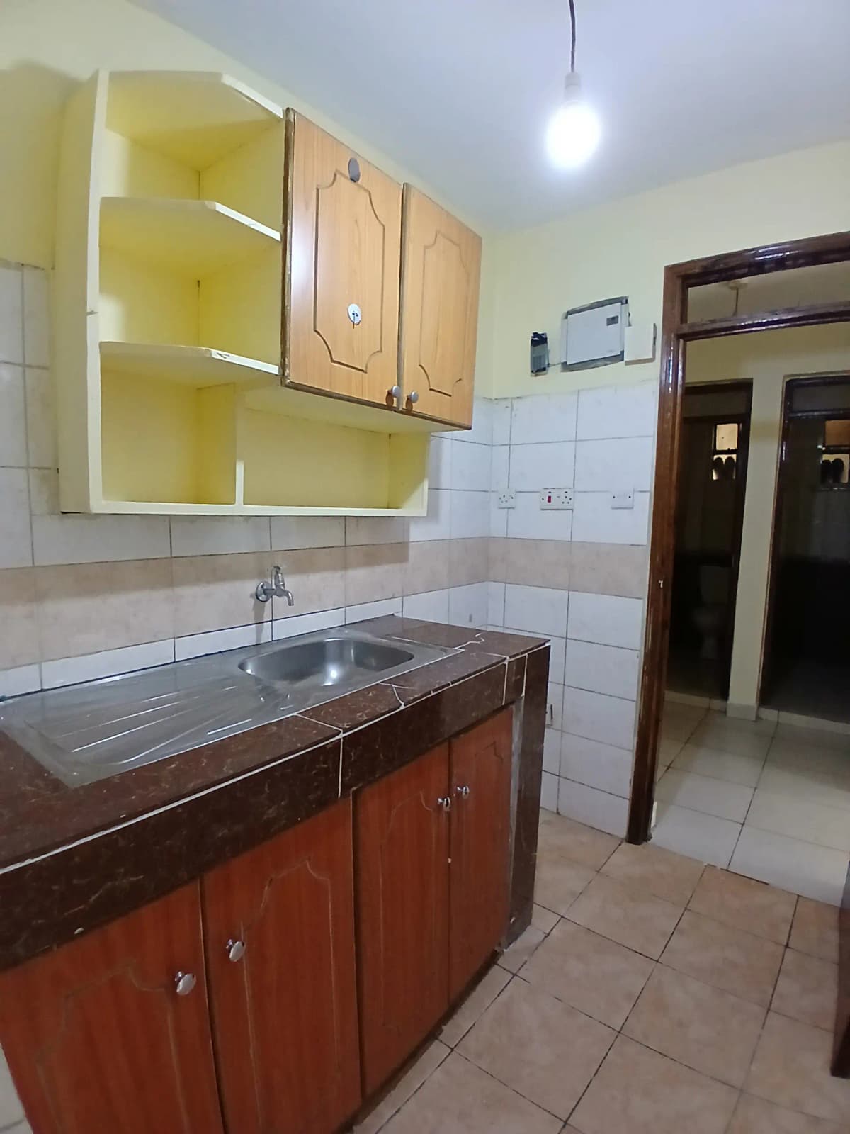 Compact kitchen with red cabinets and stainless steel sink