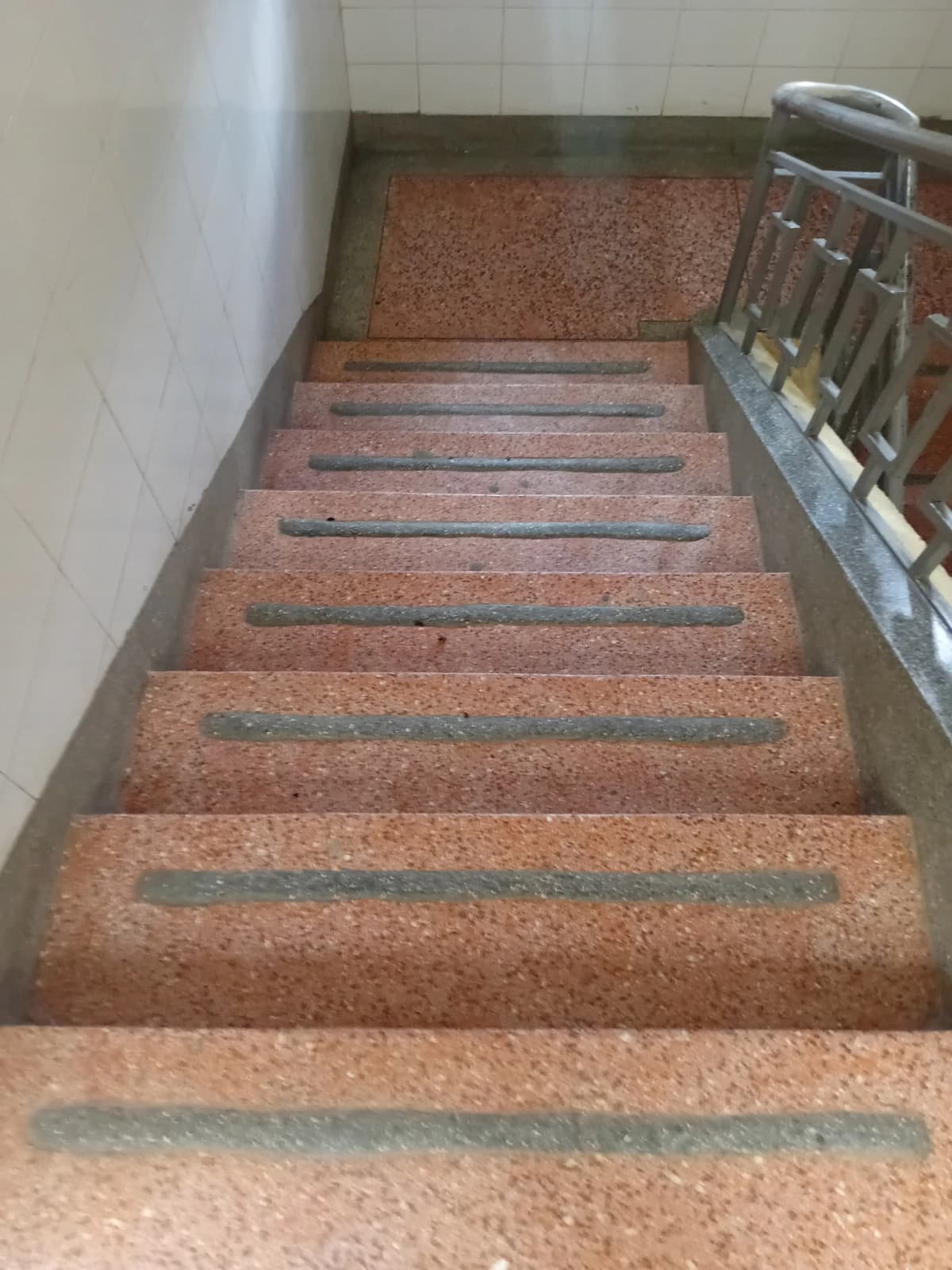 Interior staircase with cork steps and metal handrail