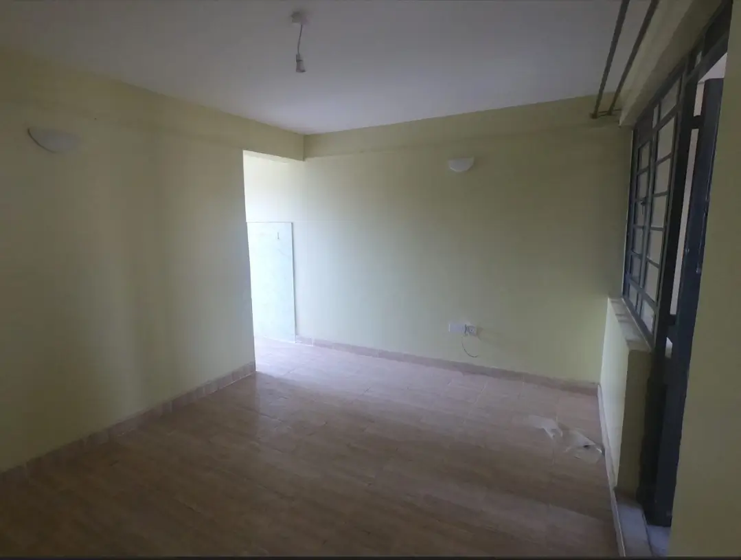 Empty living room with pale yellow walls and natural light