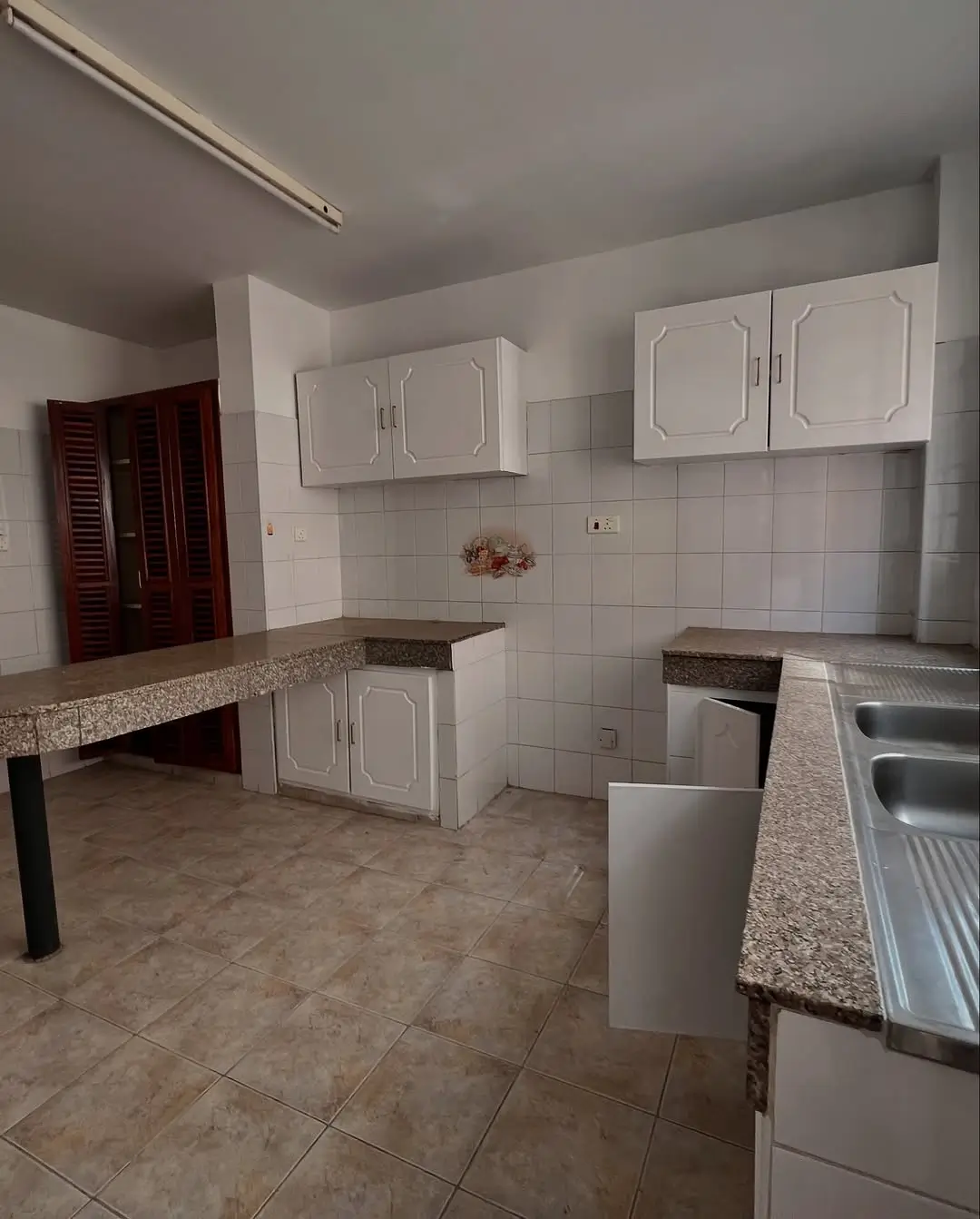 Spacious kitchen with white cabinetry and granite countertops