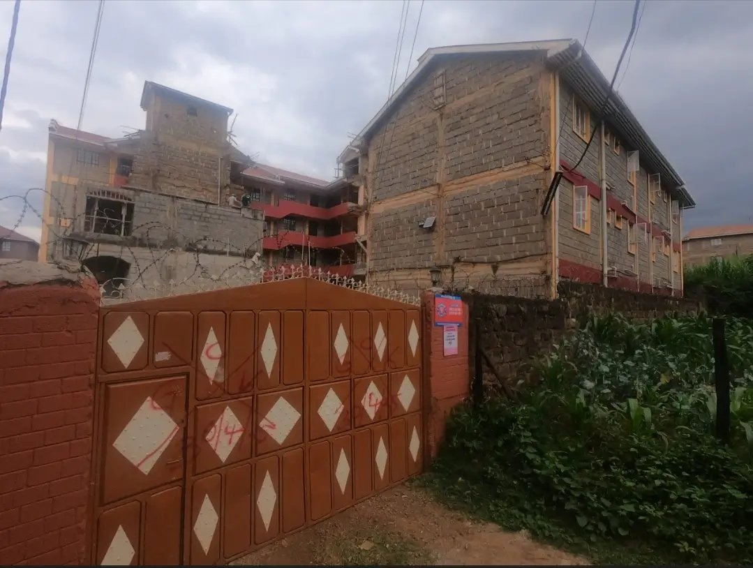 Multi-story residential building with red decorative gate entrance