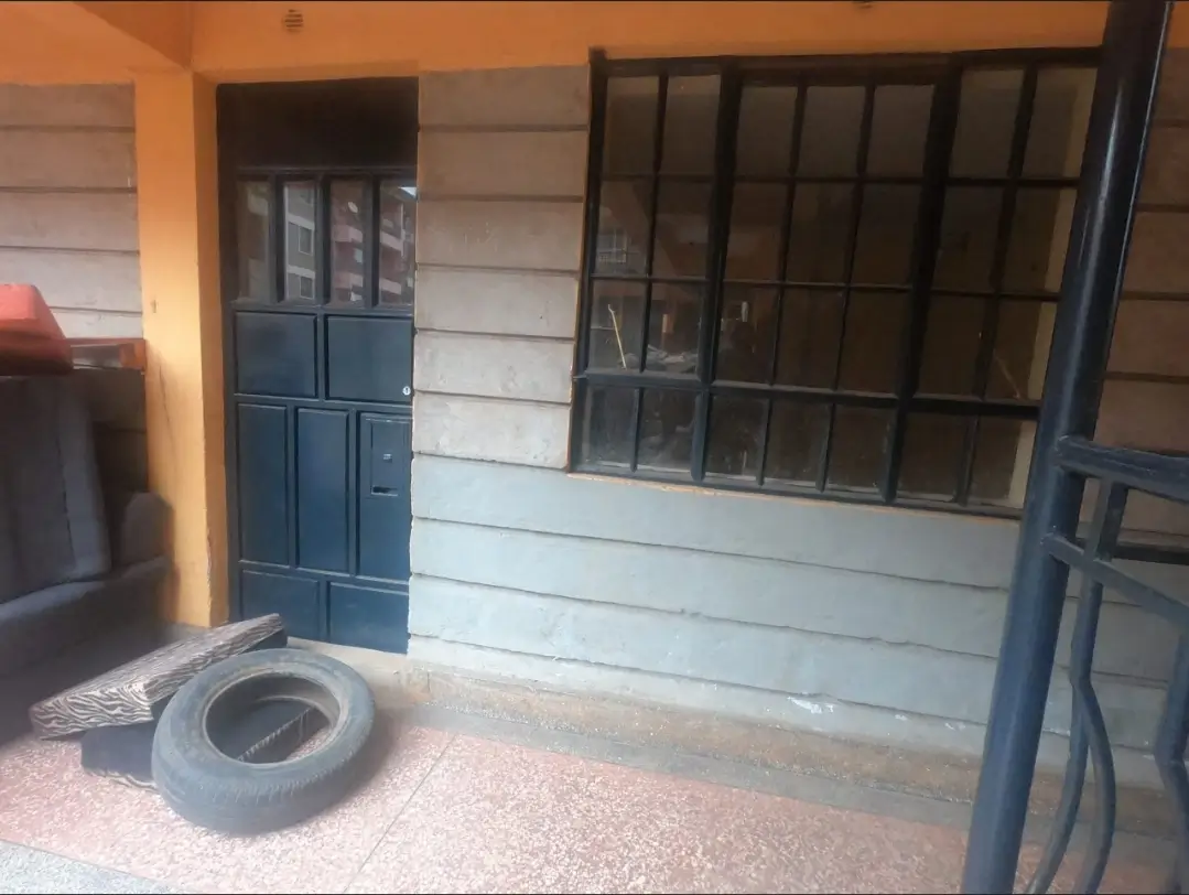 Compound entrance with blue gate and security grille