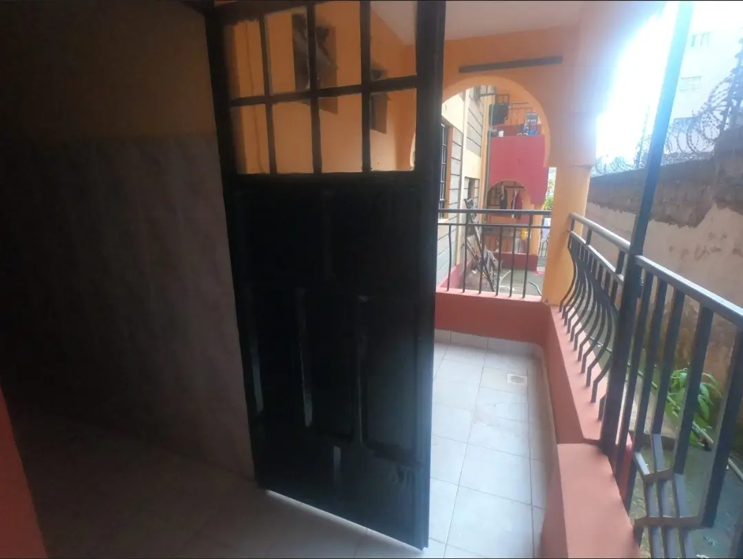 Covered balcony with red walls and metal railings