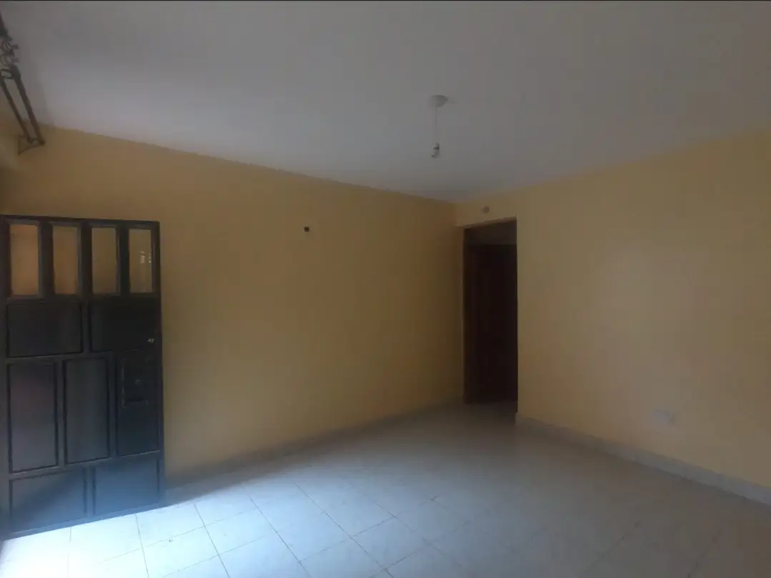 Empty living room with yellow walls and tiled flooring