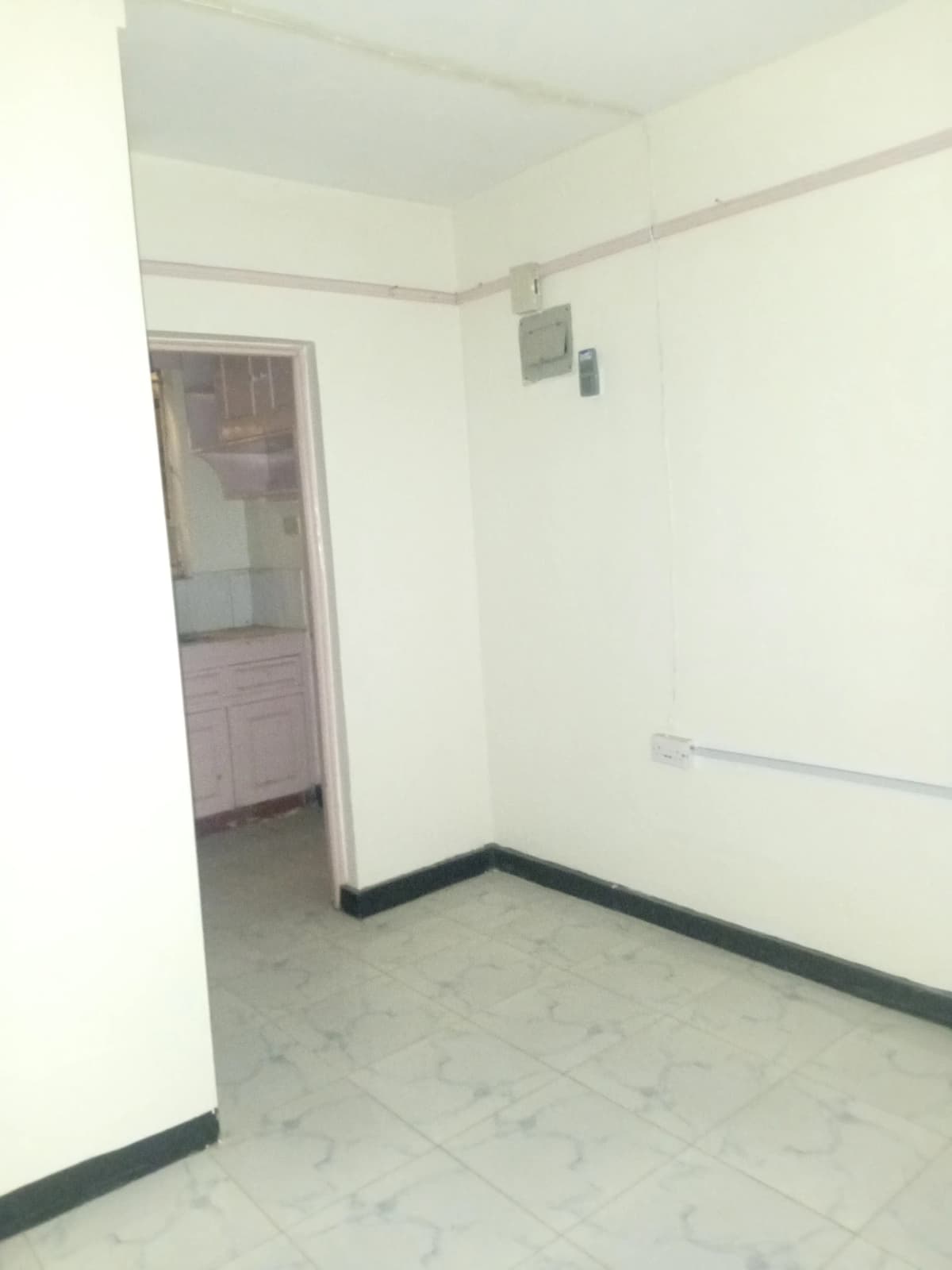 Empty bedroom with white walls and dark floor trim