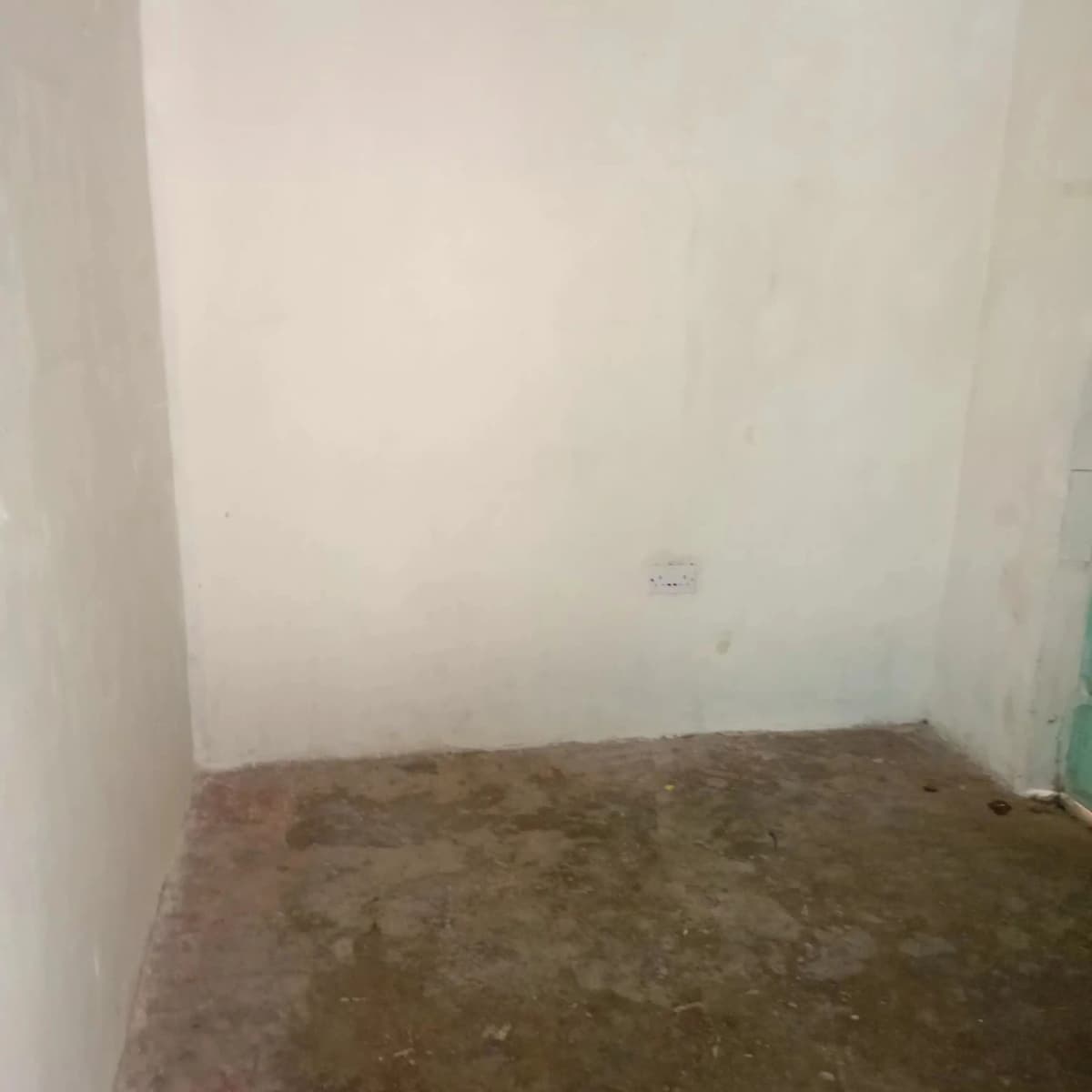 Empty room with bare concrete floor and white walls
