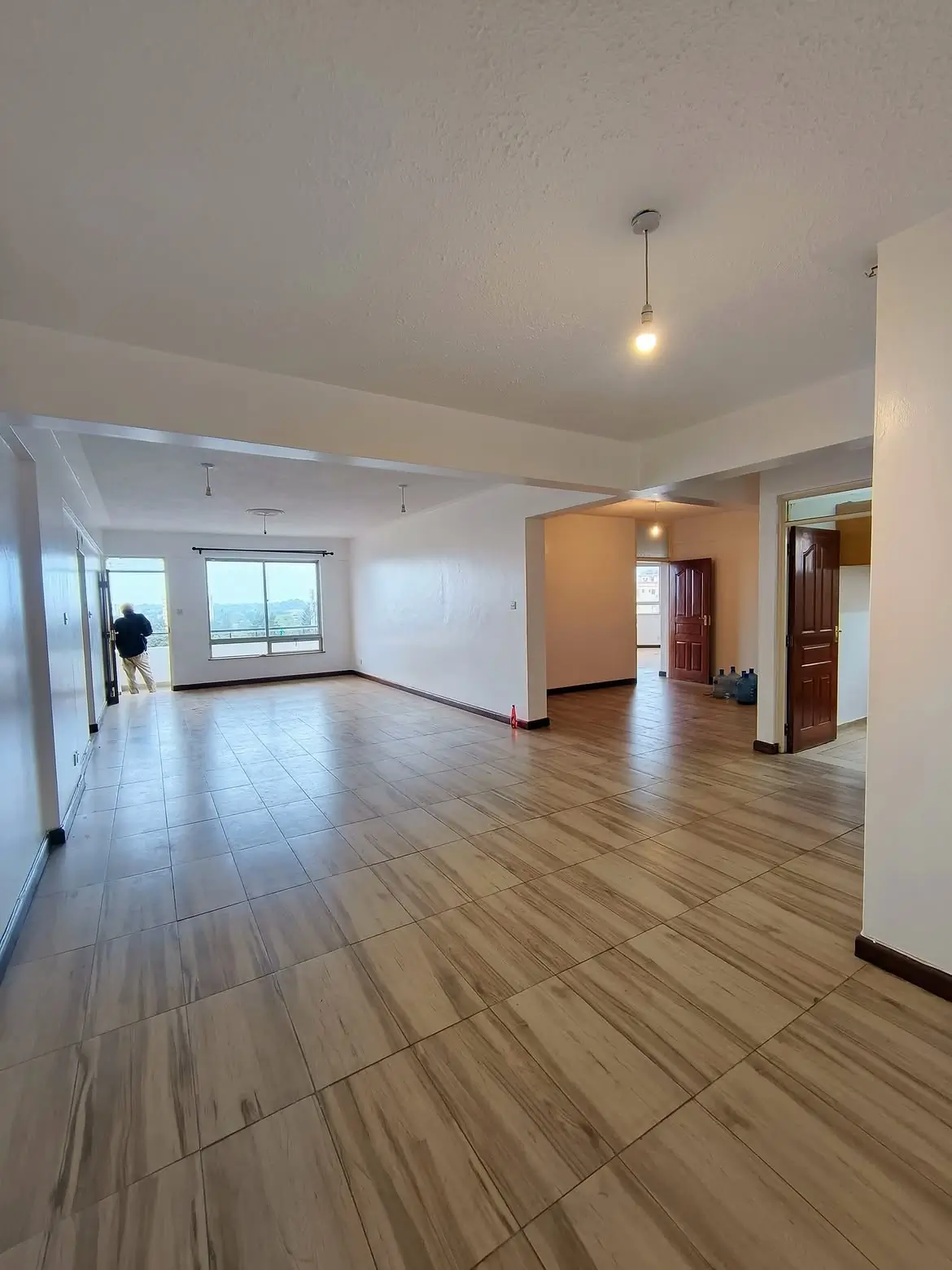 Spacious empty open-plan living room with wood-look tiles