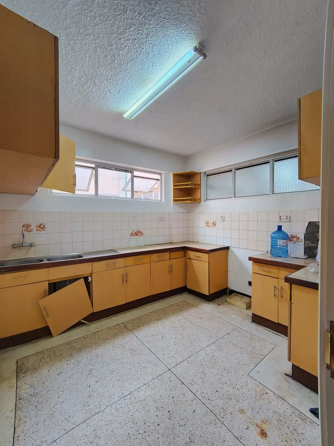 Dated yellow cabinet kitchen with damaged cupboard doors