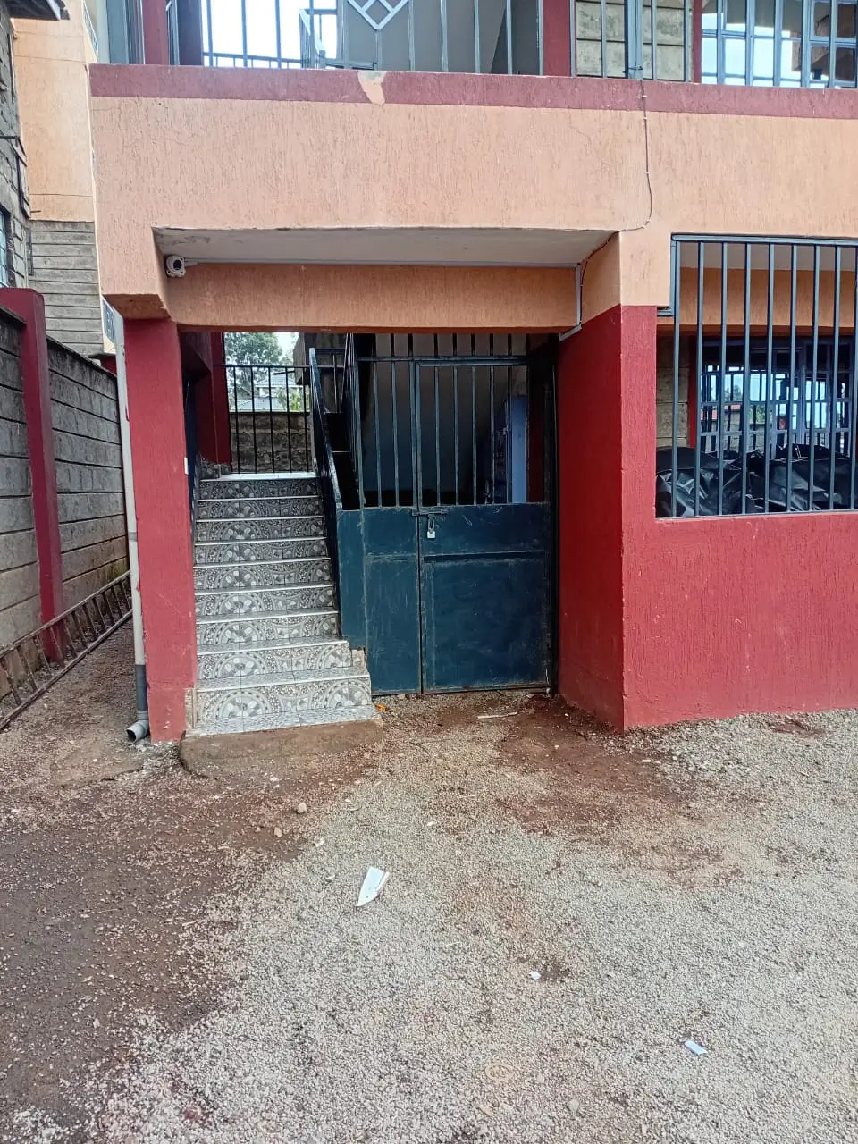 Red and beige building facade with dark blue gate entrance