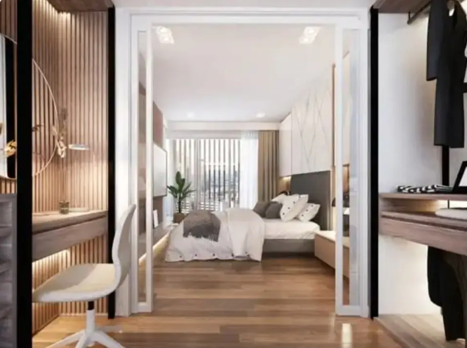 Modern bedroom viewed through walk-in wardrobe entrance