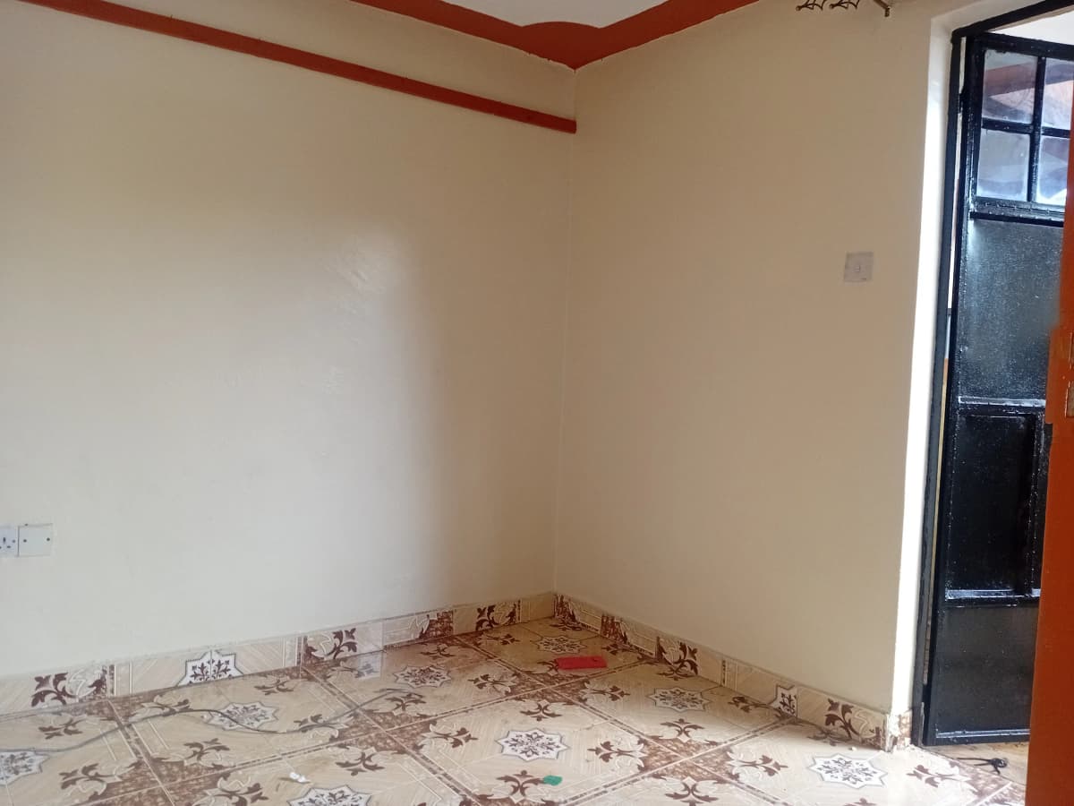 Empty bedroom with patterned floor and red ceiling trim
