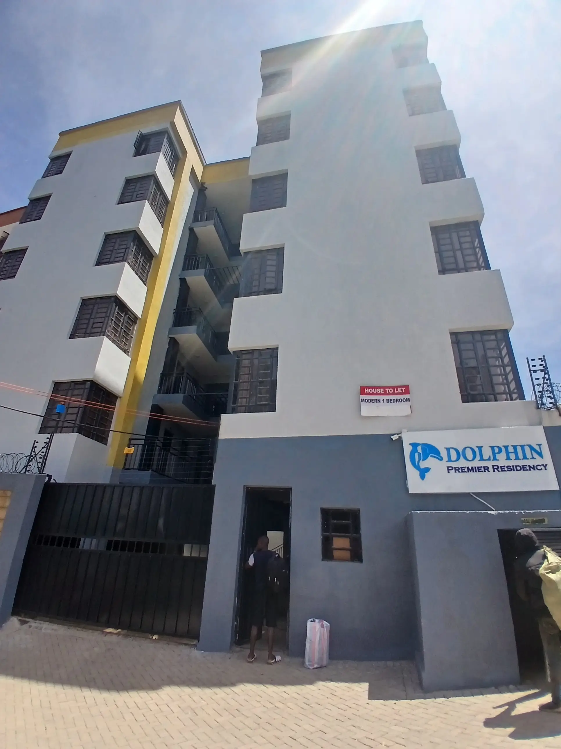 Modern multi-story residential building with yellow and white facade