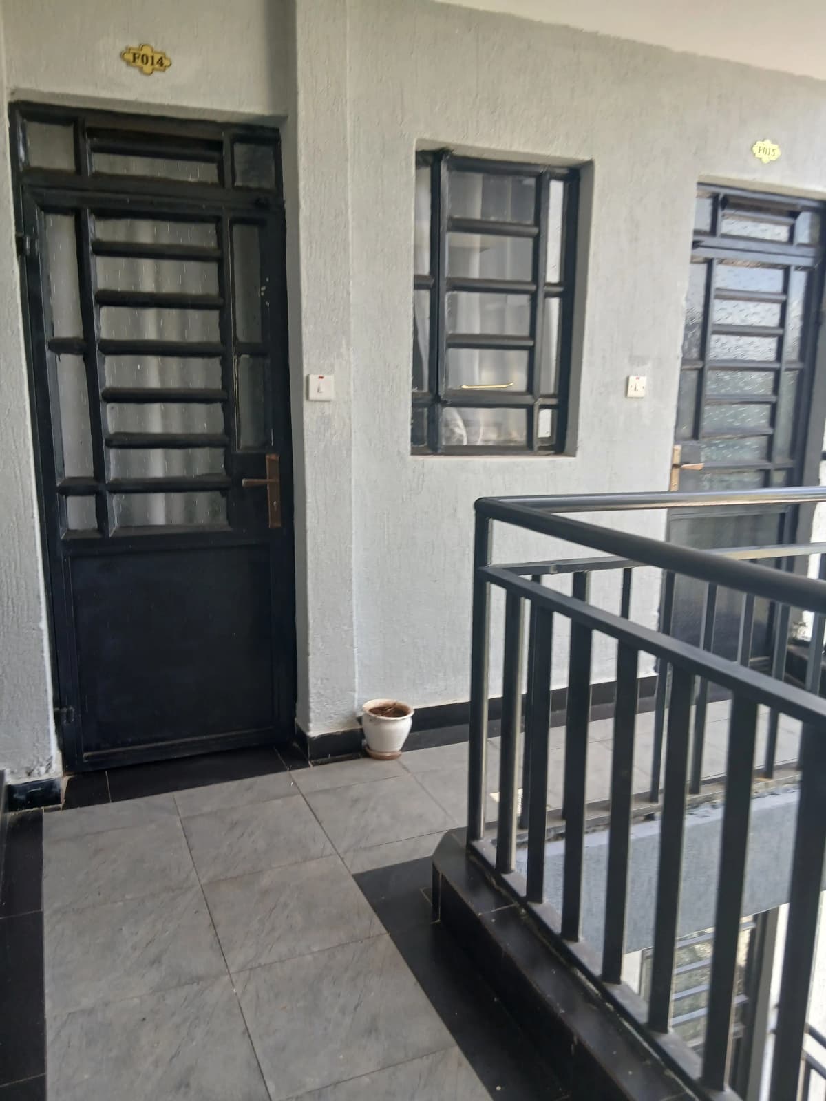 Building corridor with black door and staircase railing