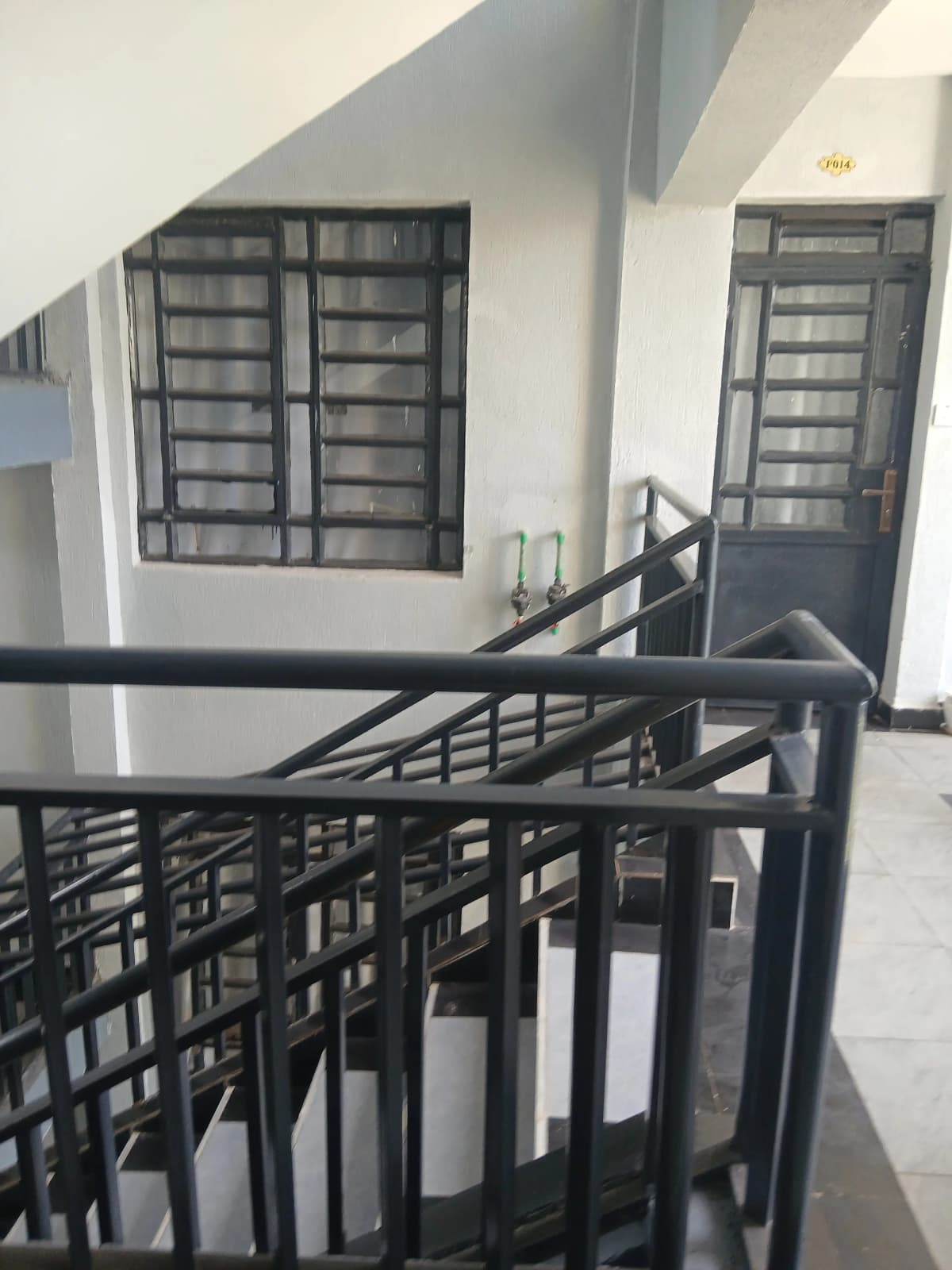 Multi-level corridor with metal staircase and security gates