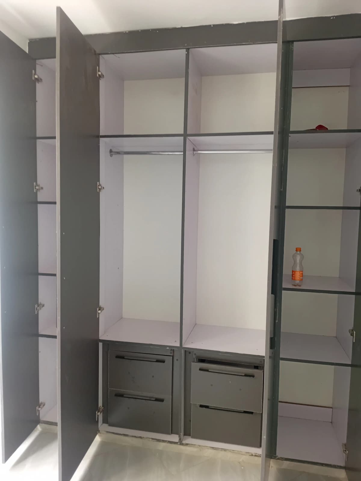 Built-in wardrobe with mirrored sliding doors and storage drawers