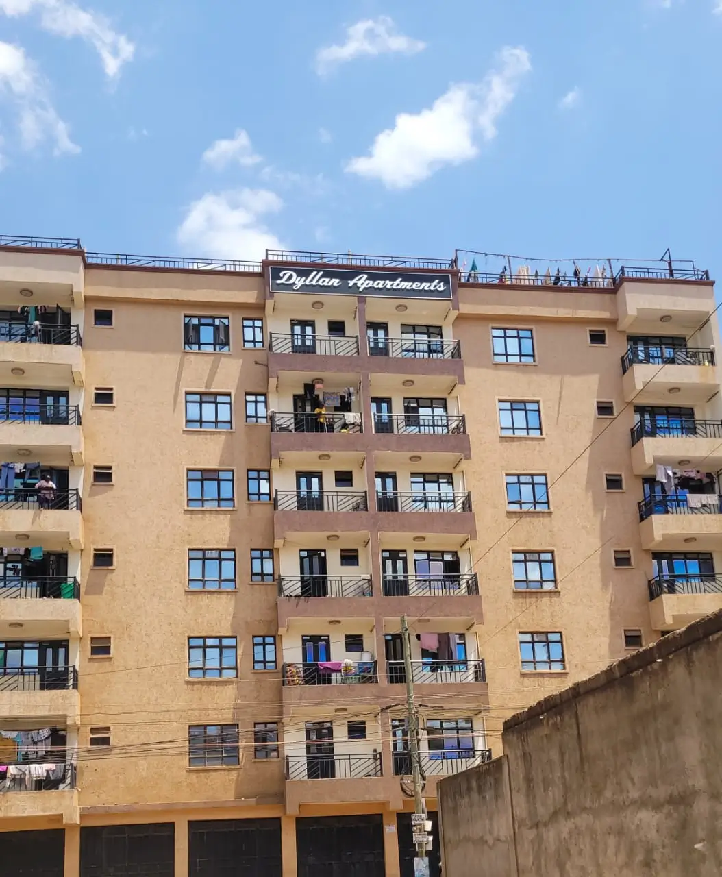 Six-story residential building with balconies and blue windows
