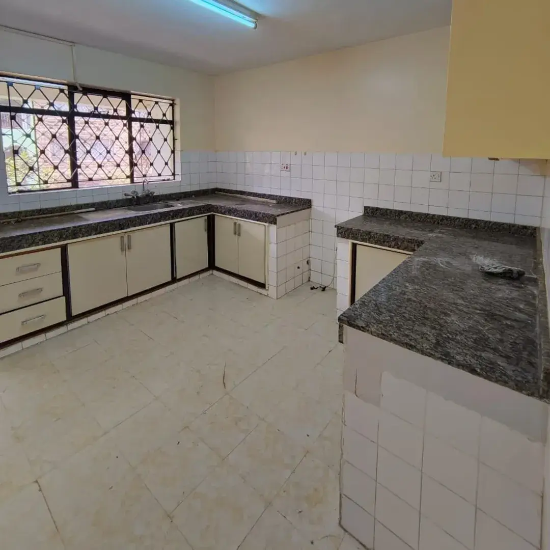 Spacious kitchen with dark granite countertops, white tiled backsplash