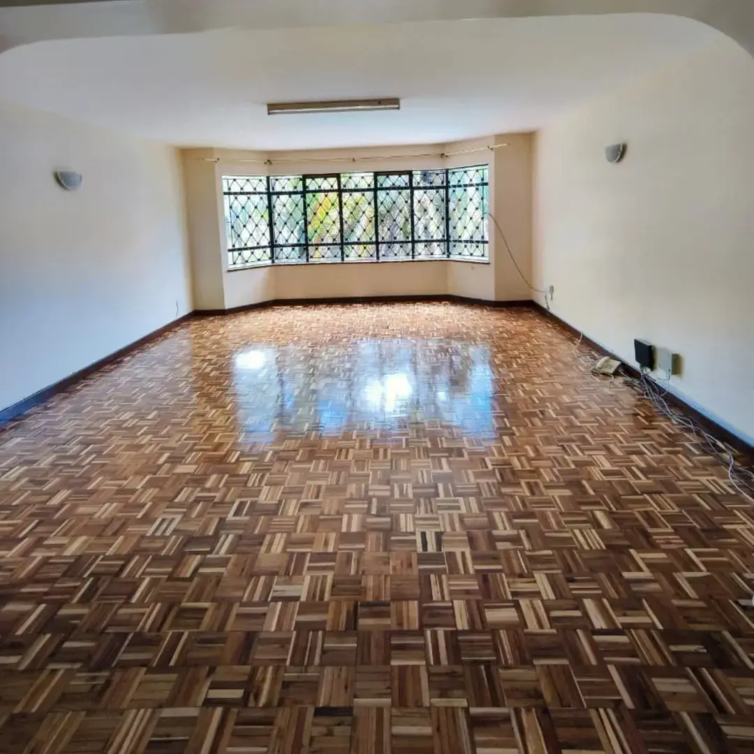 Spacious living room with parquet flooring and bay windows