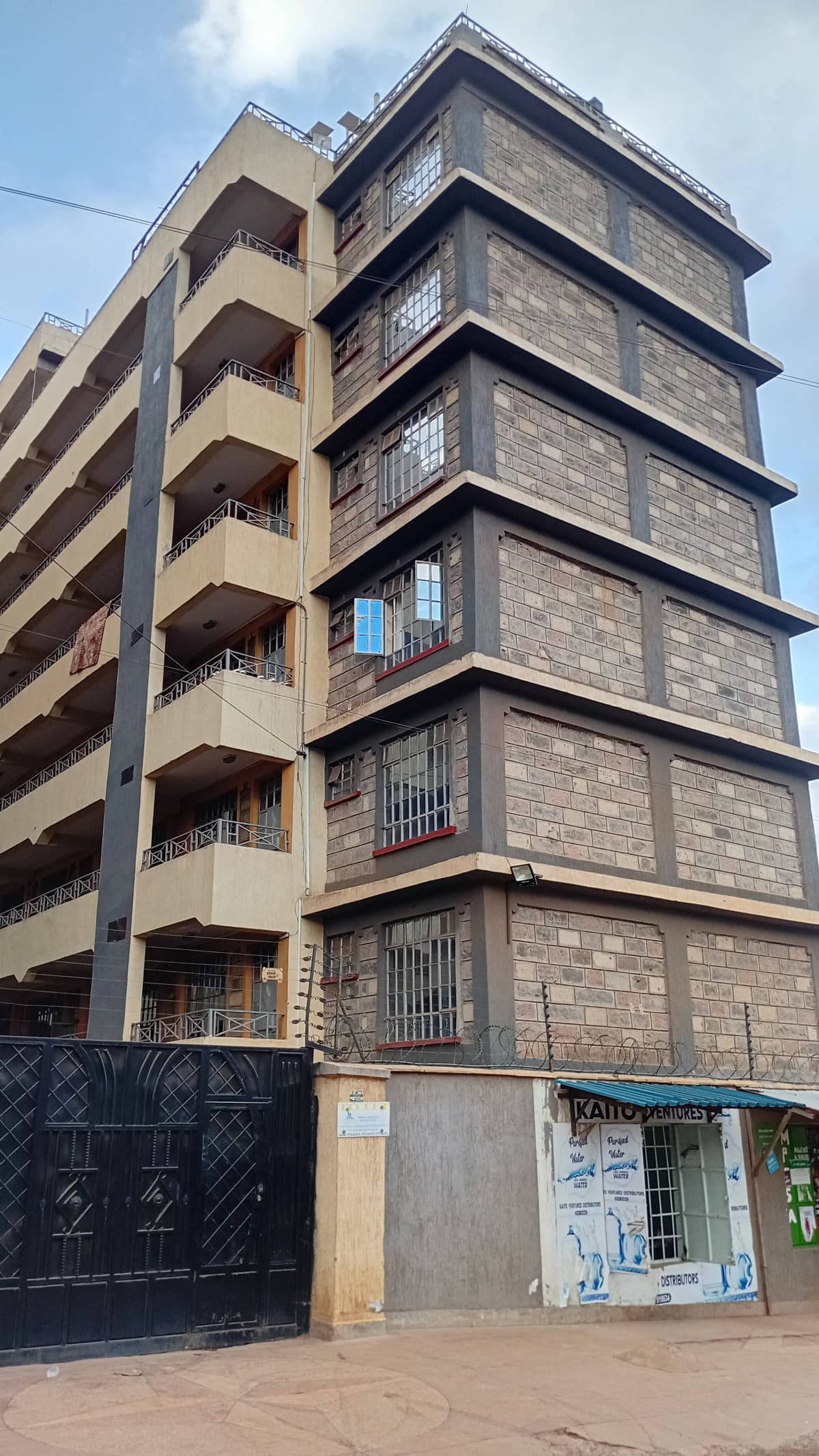 Multi-story residential building facade with balconies and ground-level shops