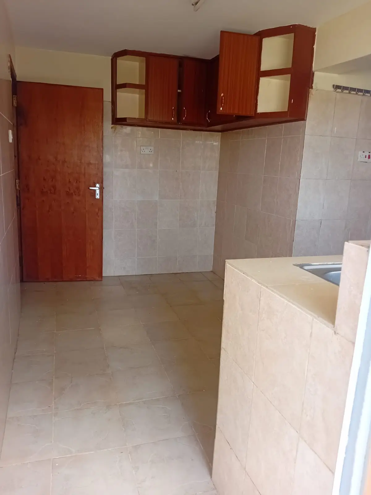 Open kitchen with red cabinets and cream counter installation