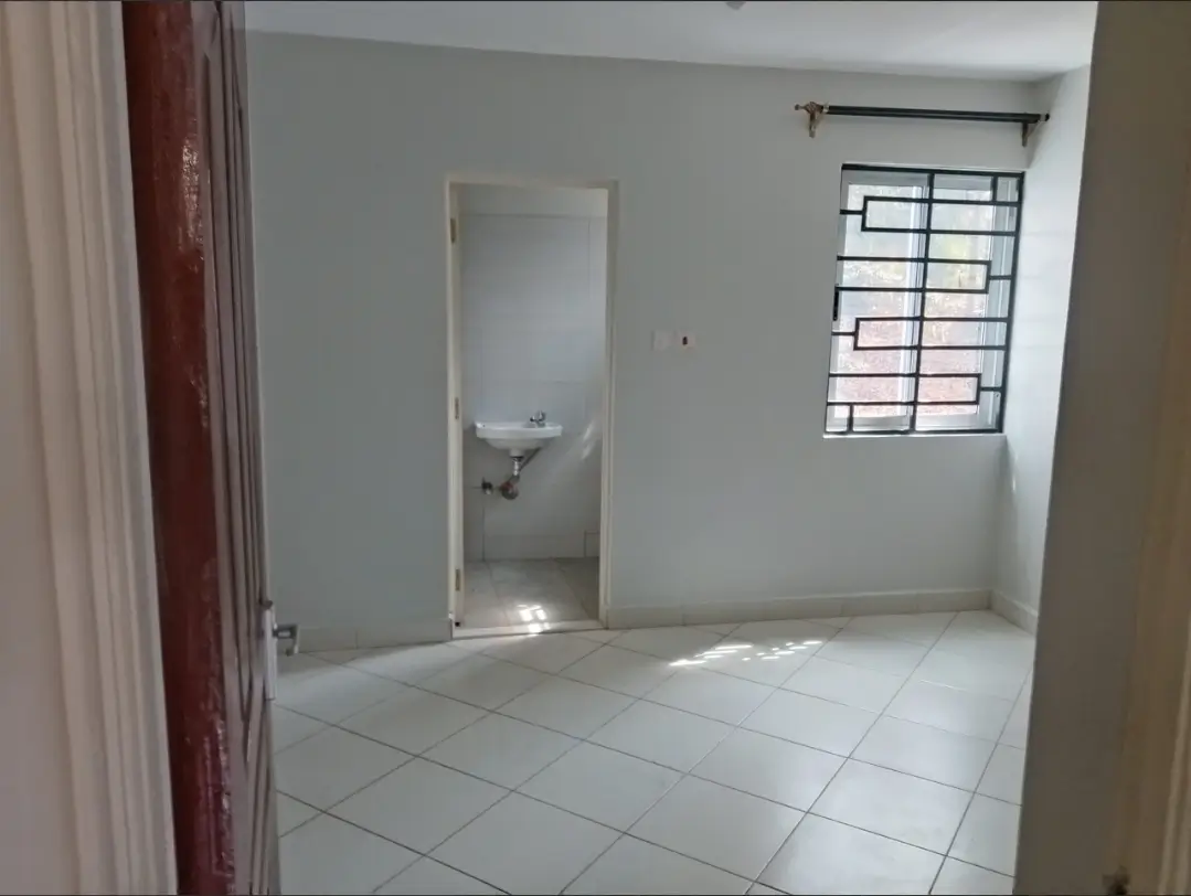 Bright bedroom with tiled flooring and barred window