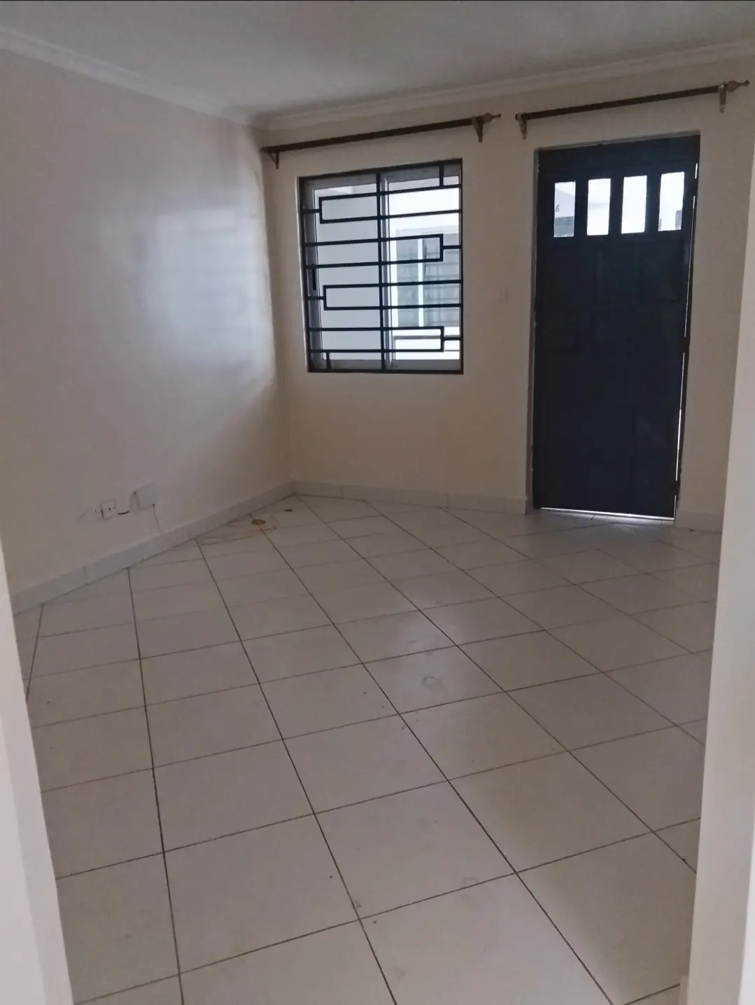 Empty corridor with tiled floor and black entrance door