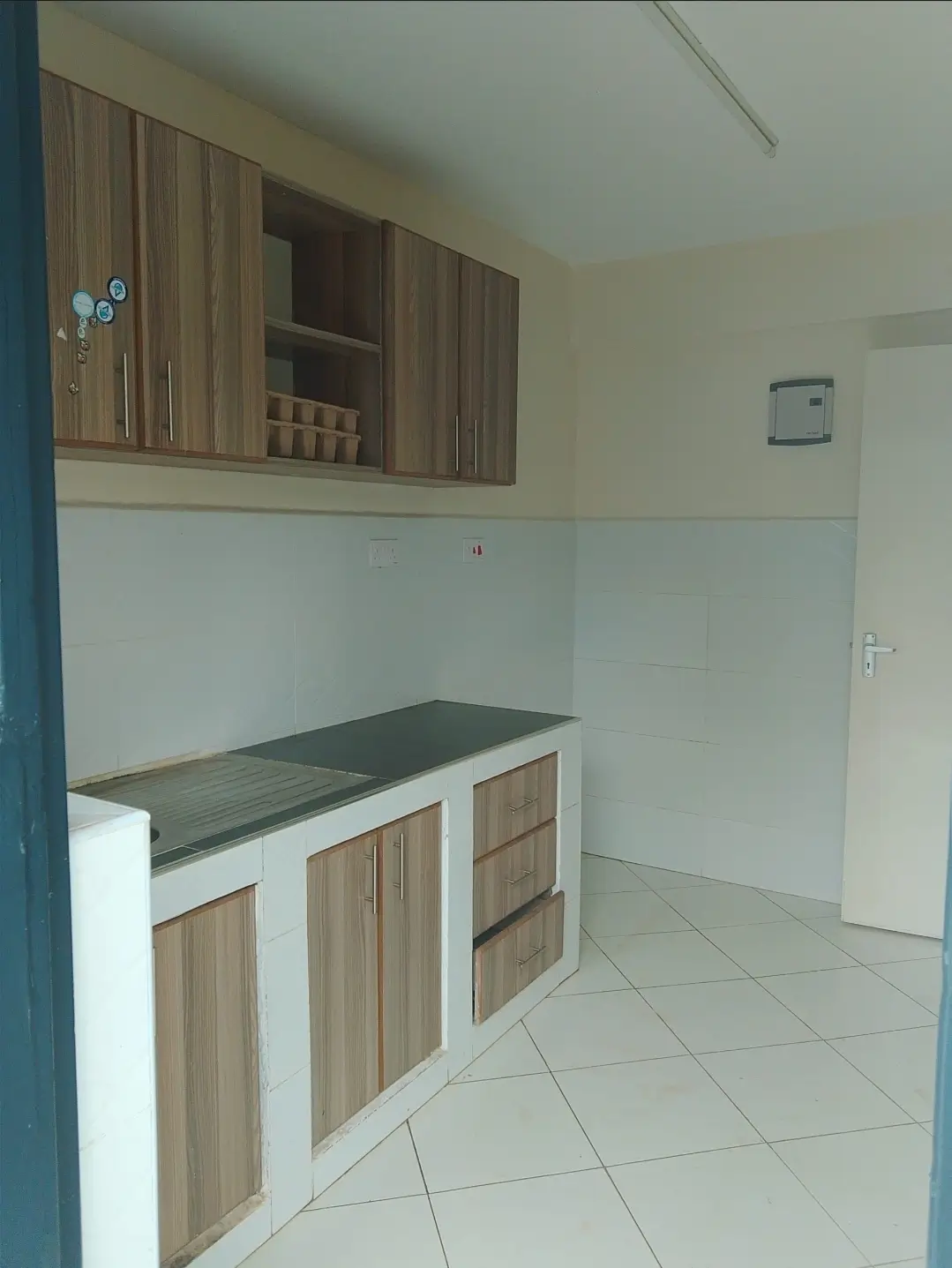 Compact kitchen with wood-grain cabinetry and dark countertop