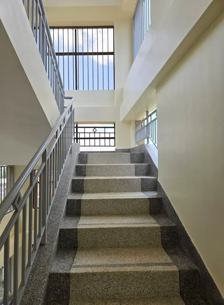 Multi-story stairwell with metal railings and skylight