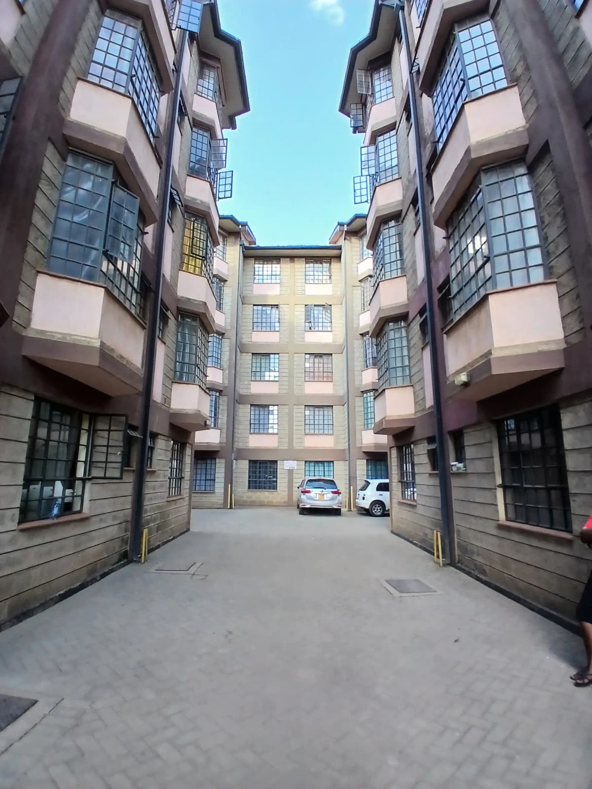 Multi-story residential building with symmetrical facade and courtyard