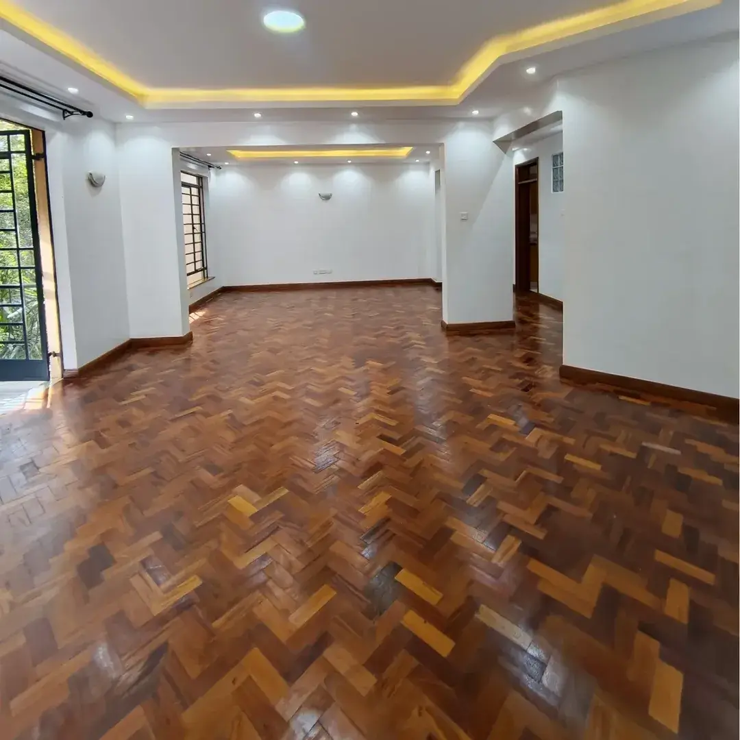Spacious living room with herringbone wooden floor and ambient ceiling lighting