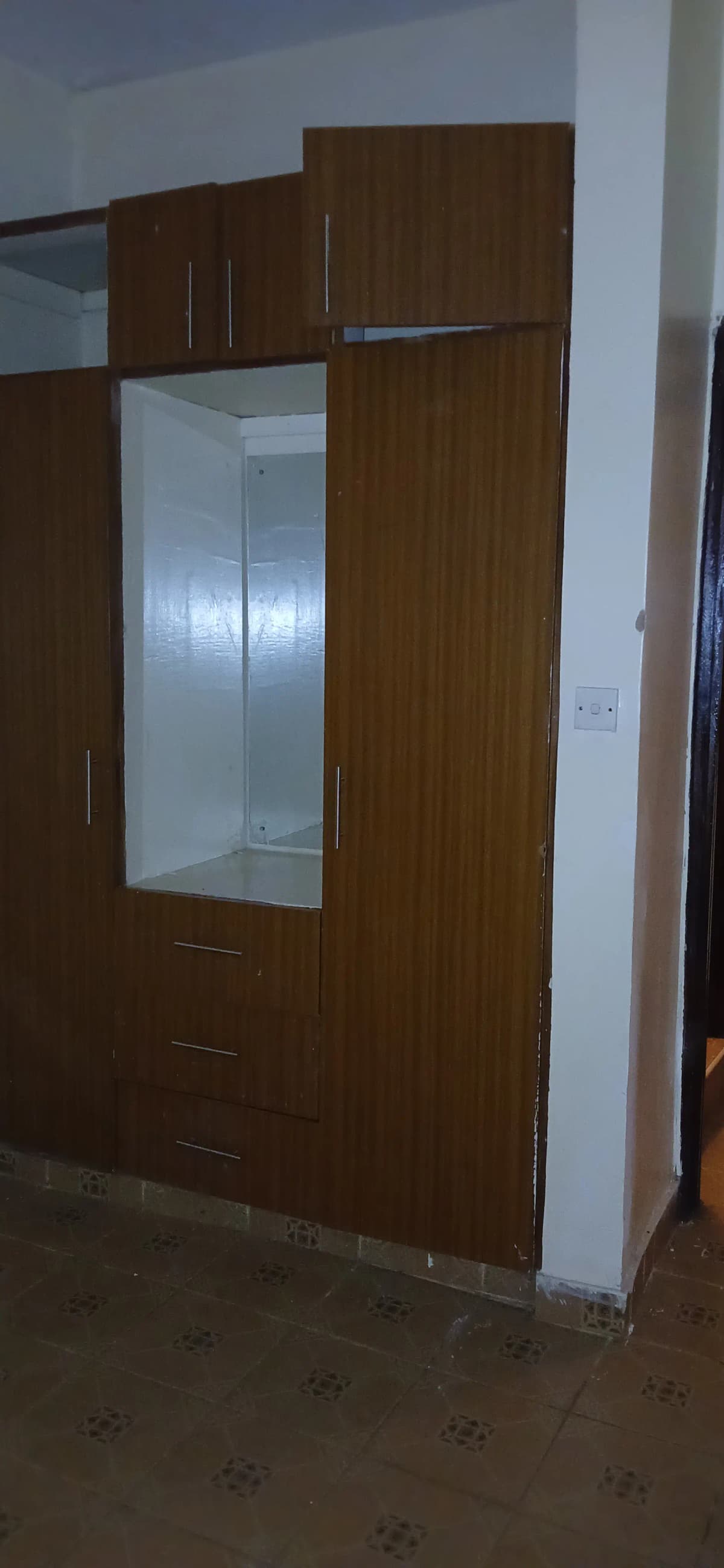 Built-in wooden wardrobe with mirror panel and storage drawers