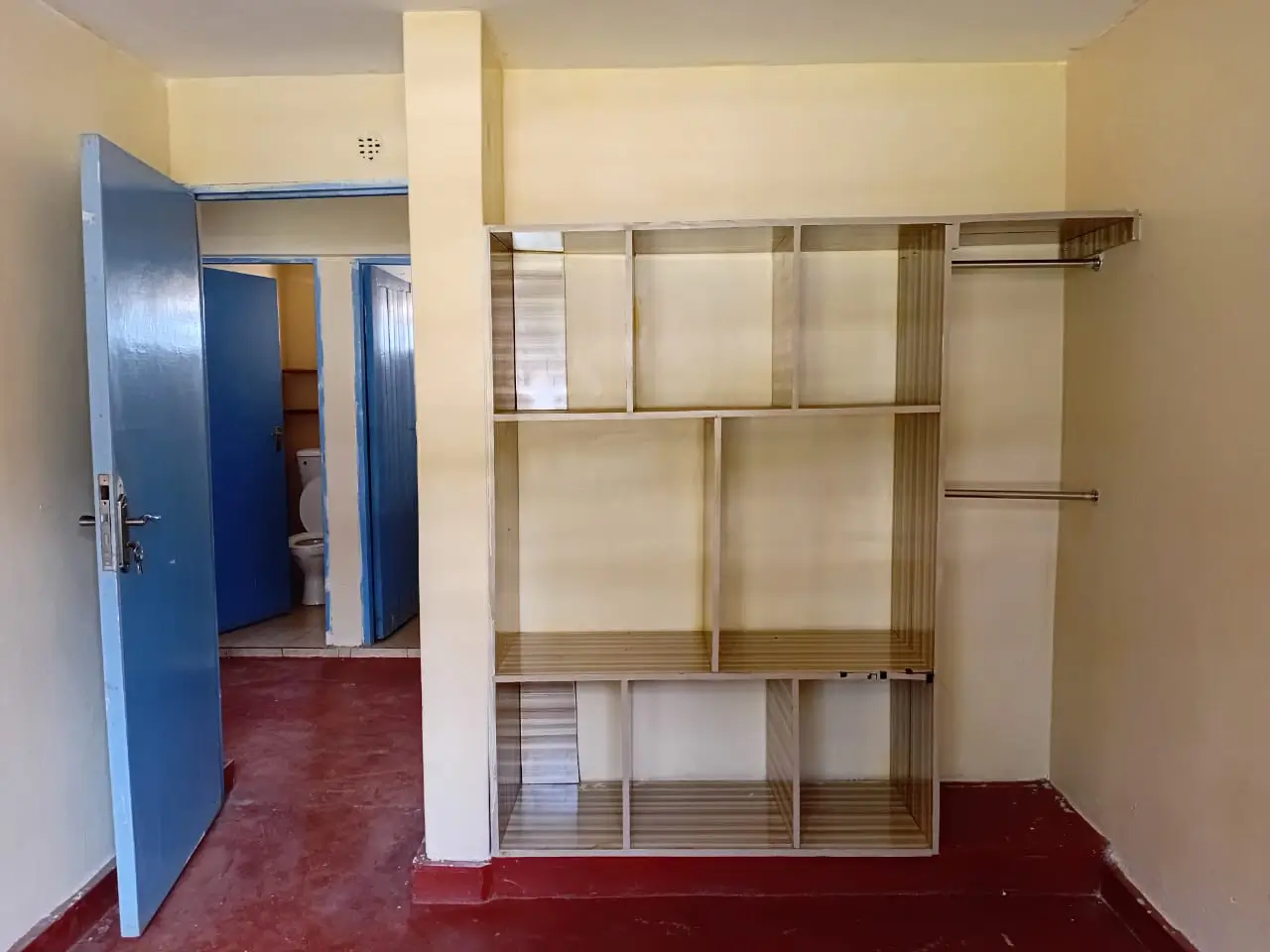 Bedroom with built-in wooden wardrobe and blue door