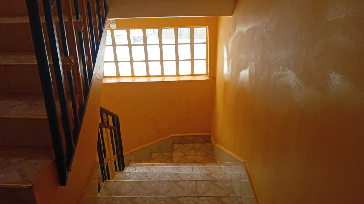 Stairwell landing with orange walls and natural light