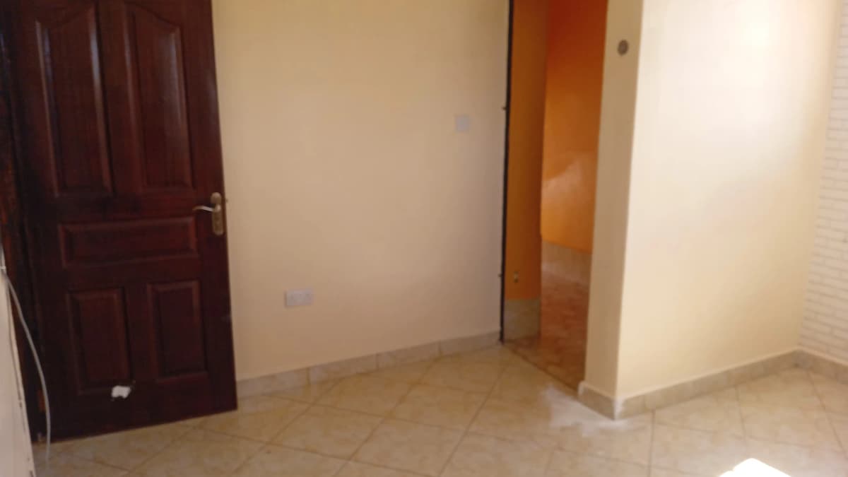 Empty bedroom with tiled flooring and wooden door