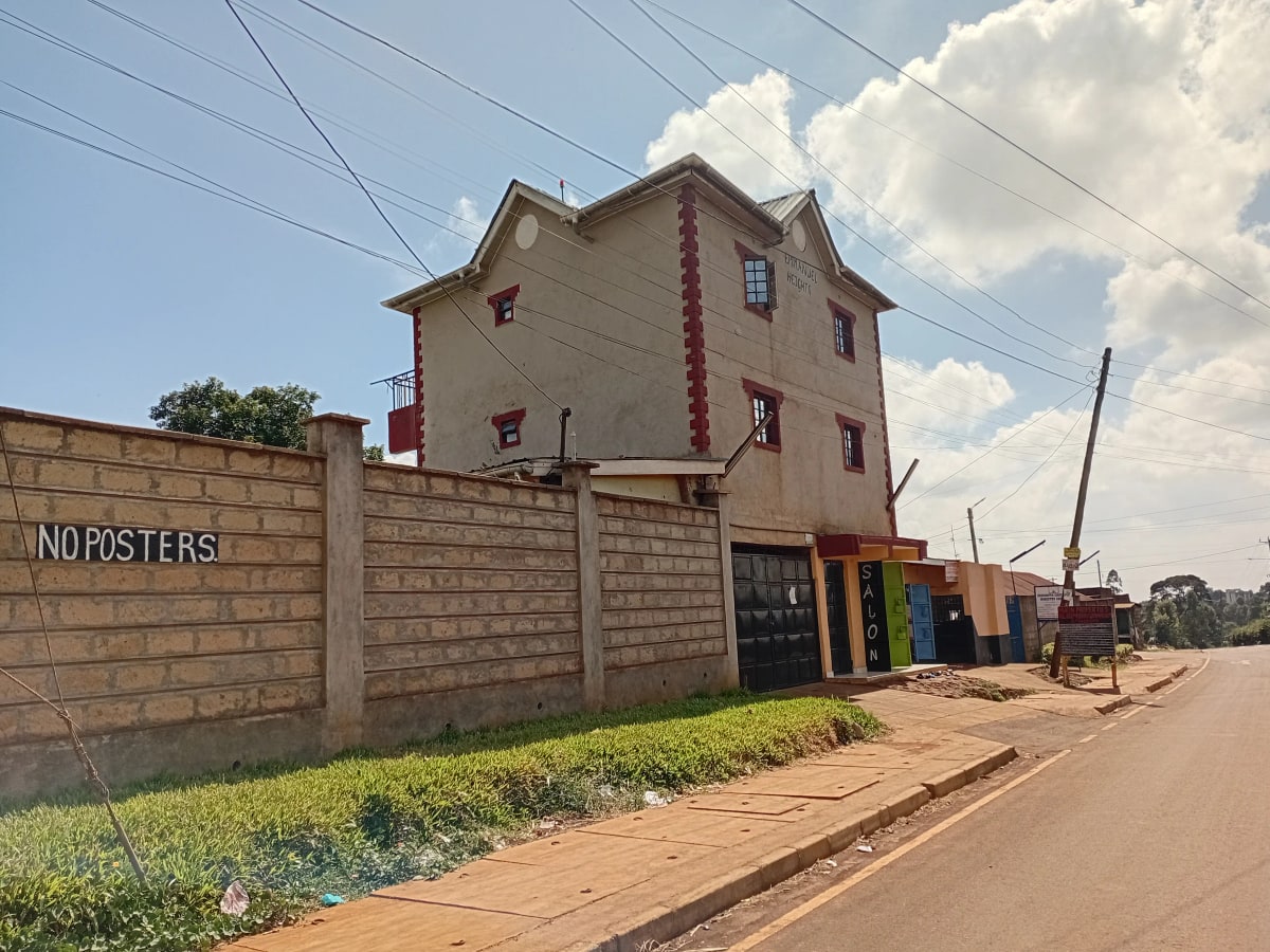 Three-story residential building with perimeter wall and gate