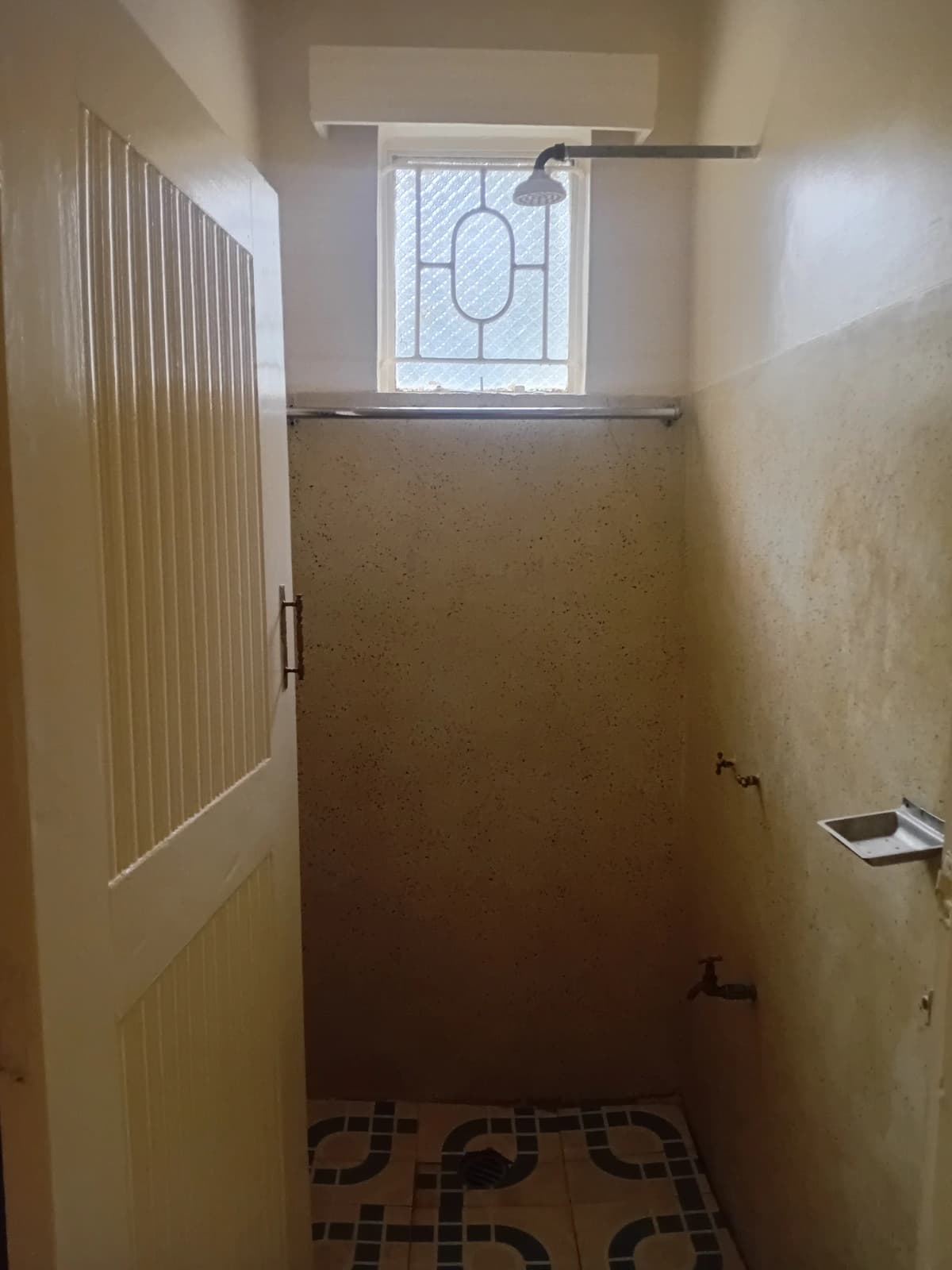 Compact bathroom with shower enclosure and small window
