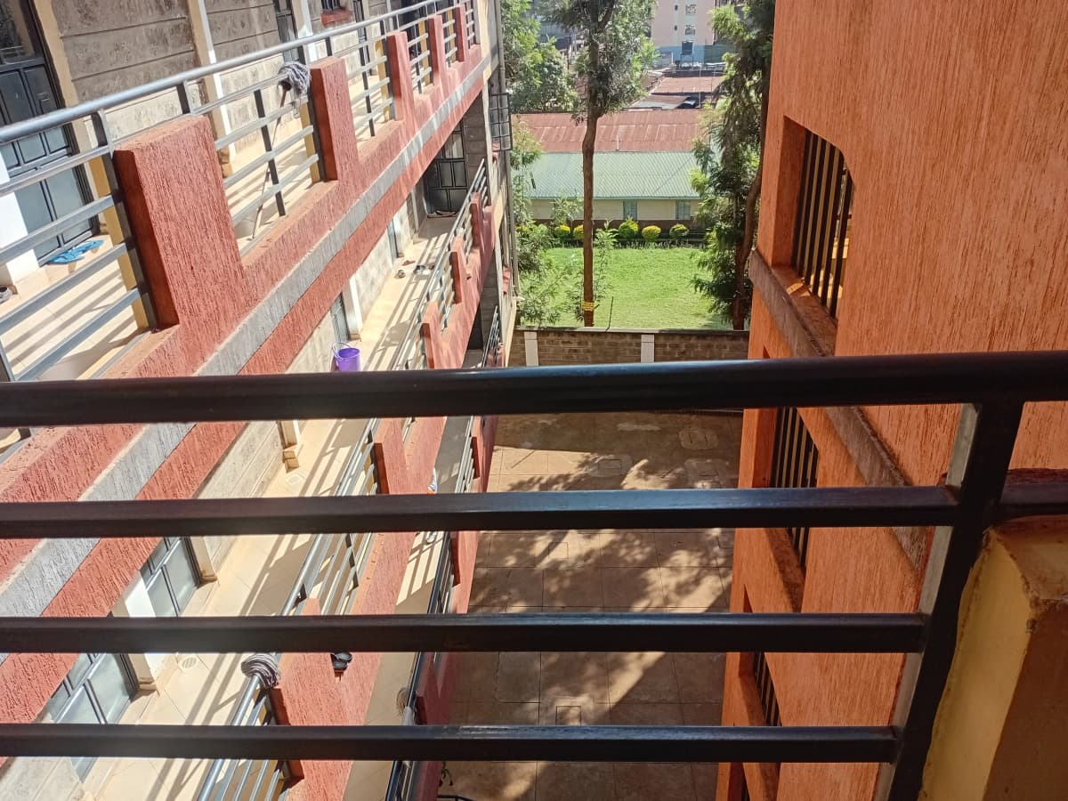 Balcony view overlooking compound grounds and landscaped lawn