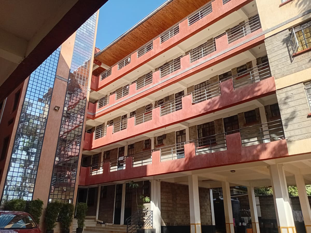 Multi-story residential building with pink facade and balconies