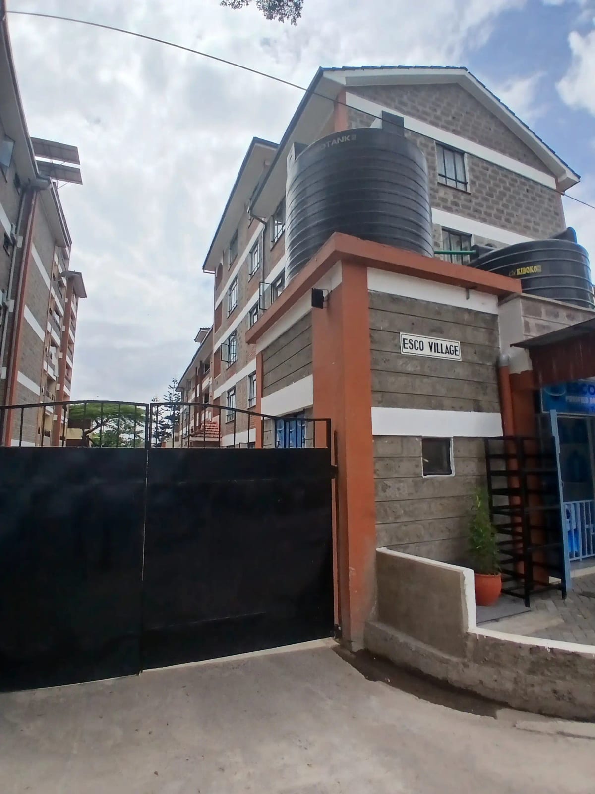 Multi-story residential building with metal gate entrance