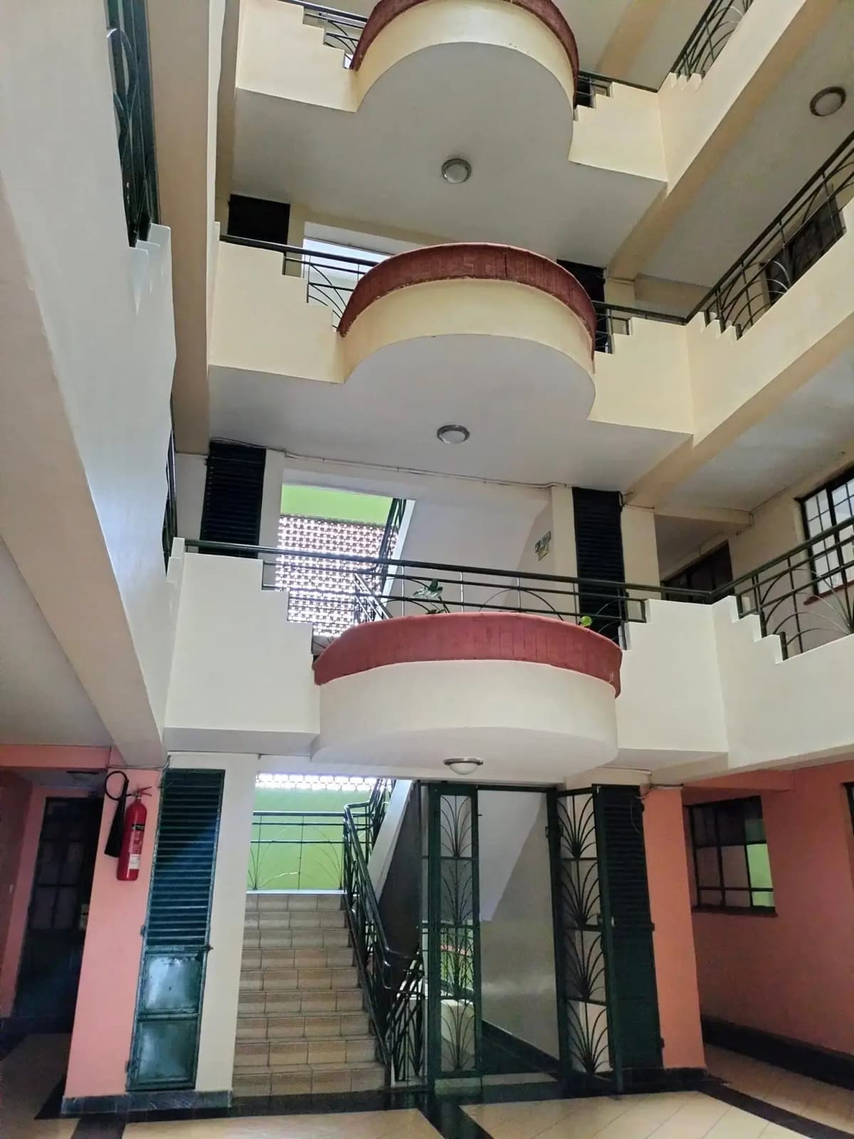 Multi-level building atrium with curved balconies and staircase