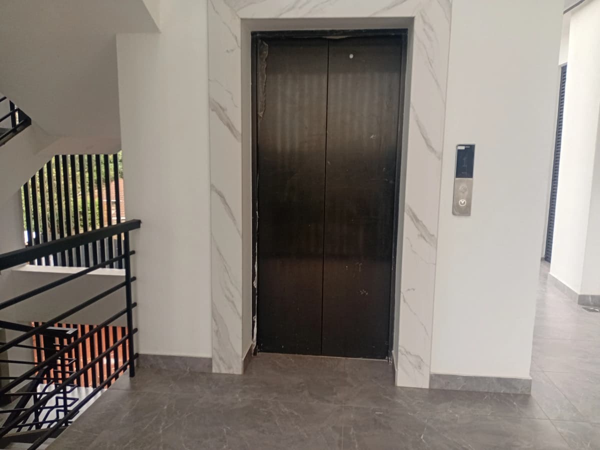 Modern elevator lobby with marble walls and digital panel