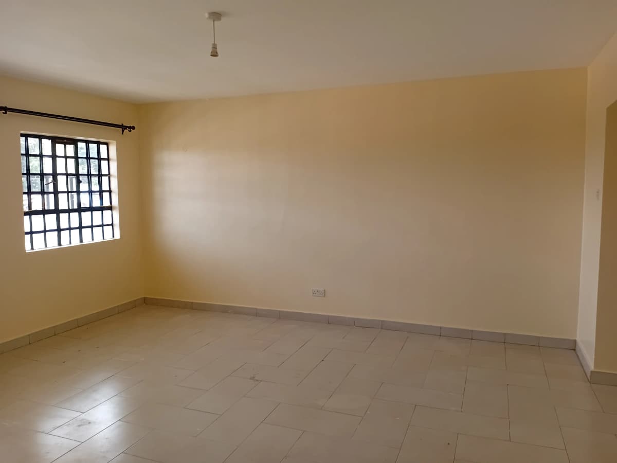 Empty living room with tiled flooring and barred window