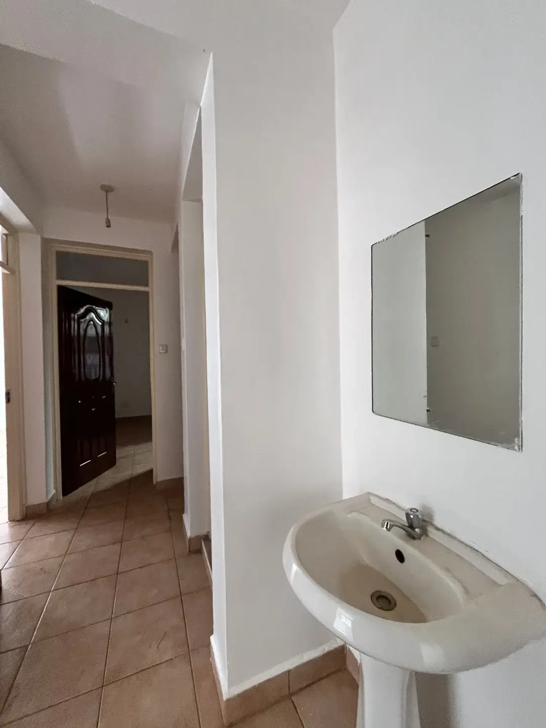 Compact bathroom with pedestal sink and mirror