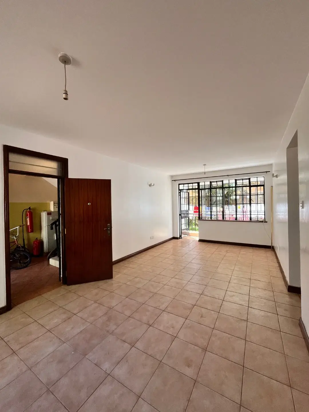 Spacious living room with terracotta tiles and natural light