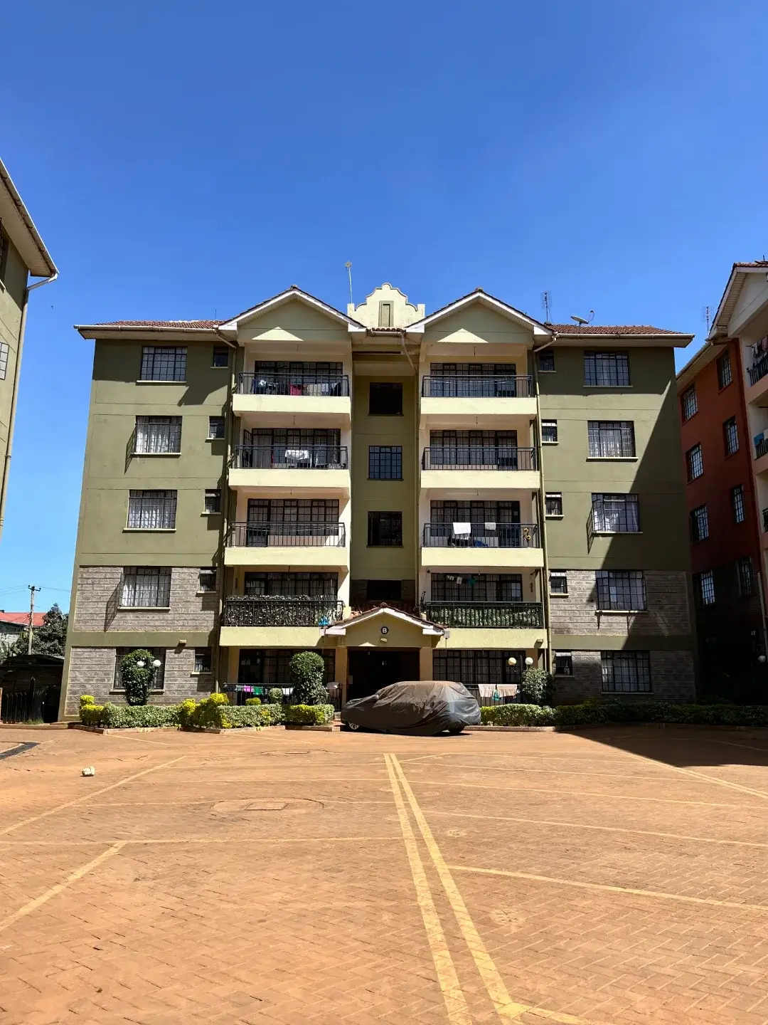Multi-story residential apartment building with parking compound