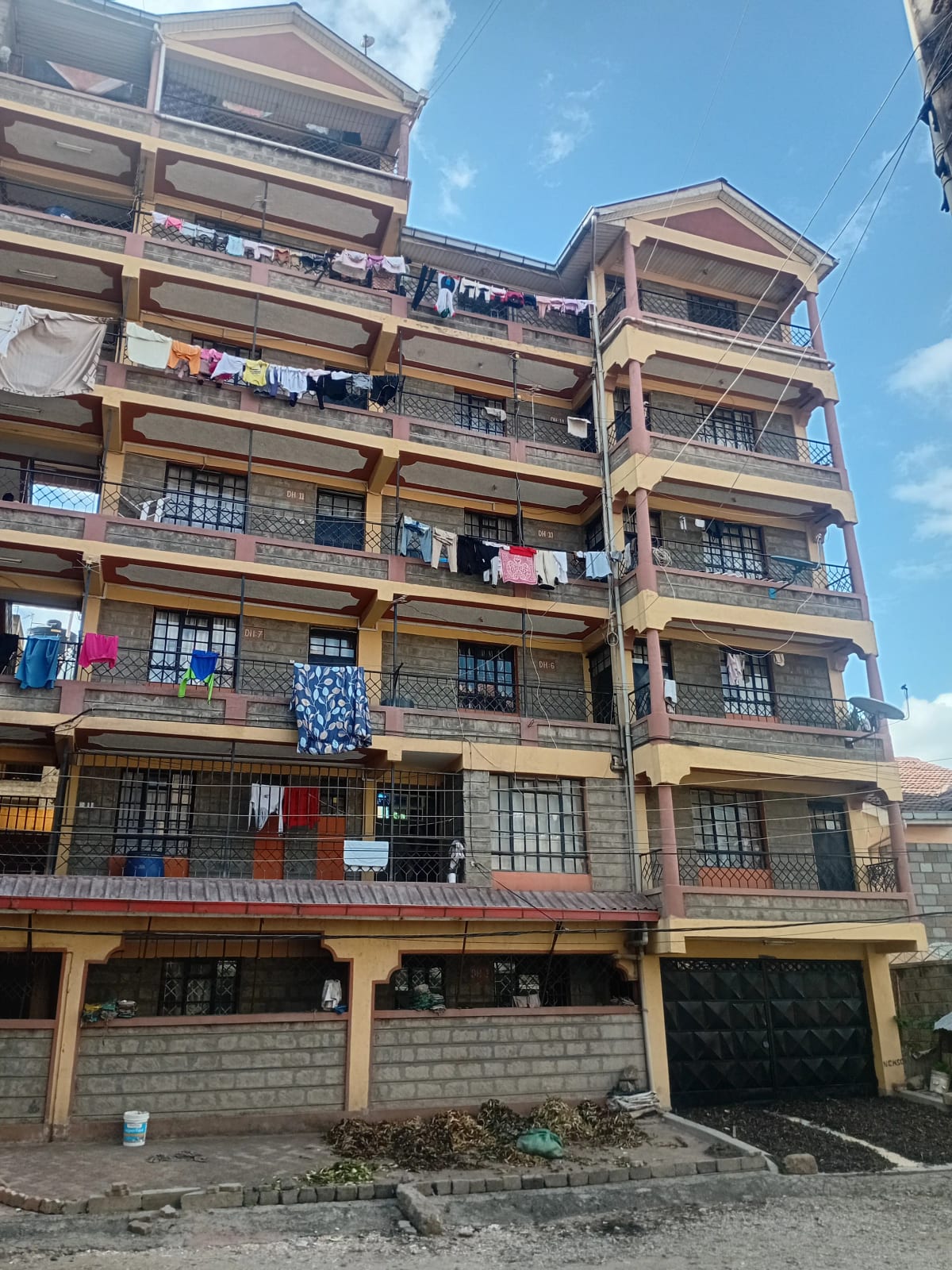 Multi-story residential building facade with balconies and ground parking