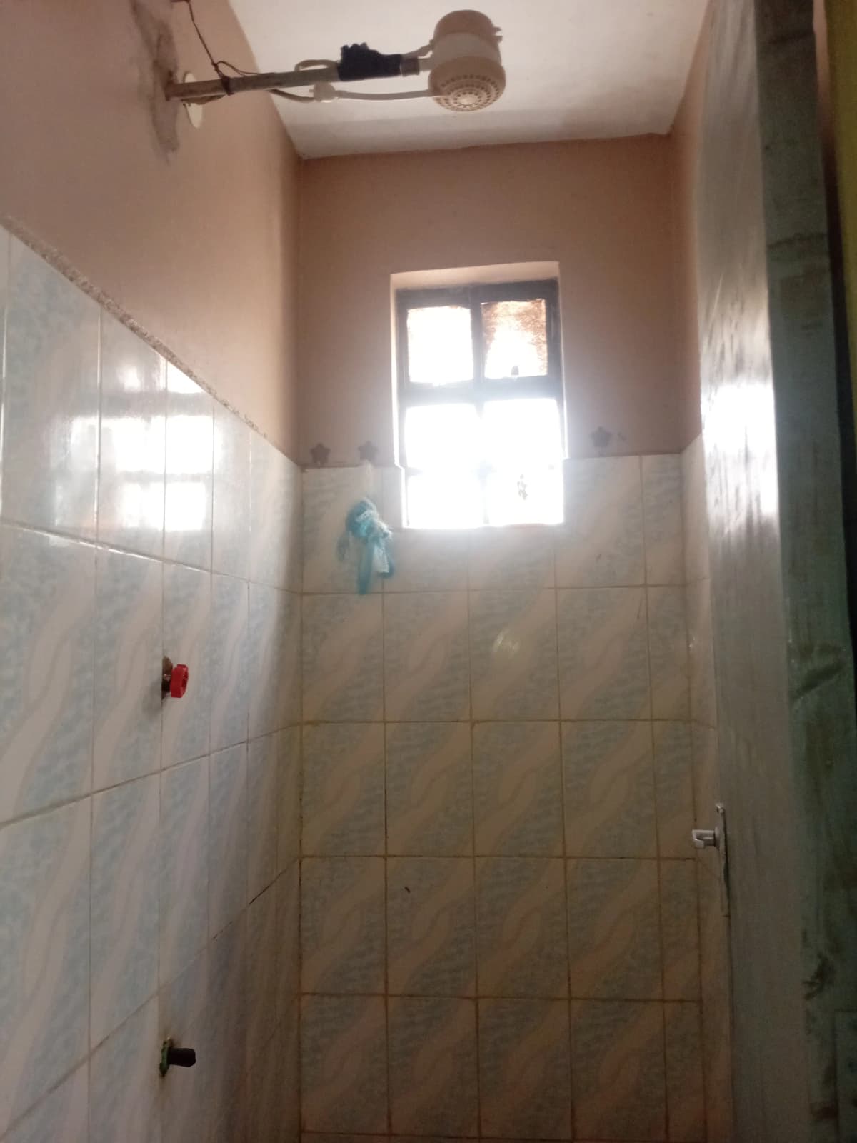 Simple bathroom with tiled walls and window for natural light